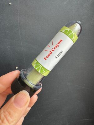 Lime Food crayon in front of a black background