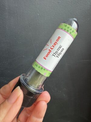 Thyme Food crayon in front of a black background