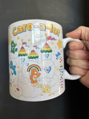 Front of the Care-a-Lot coffee mug featuring all the Care Bears