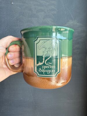 The Lord of the Rings green and brown mug with the sign of the Green Dragon Inn on it.