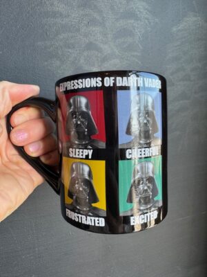 Black mug with four colour panels, each with a different named facial expression but the same picture of Darth Vader.