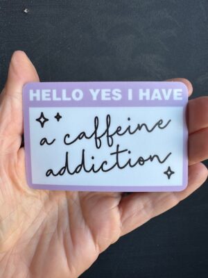 Vinyl sticker like a purple nametag stating "Hello, Yes I have" and "a caffeine addiction" written in cursive.