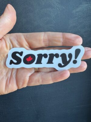 Vinyl sticker with black letters on white background, "Sorry!" middle of letter o is a red maple leaf.