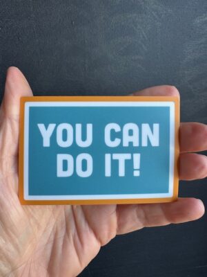 Vinyl sticker with orange border, blue background and white text that reads "You Can Do It!"