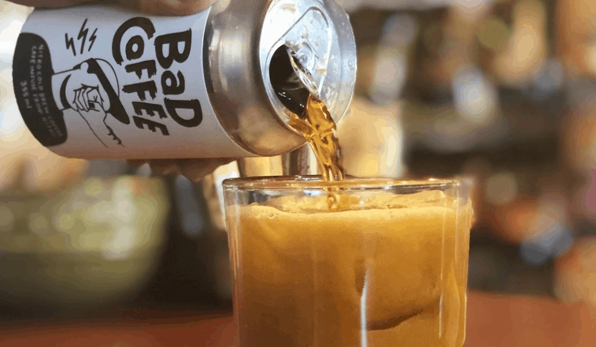 BAD cold brew nitro coffee pouring from a can into a glass