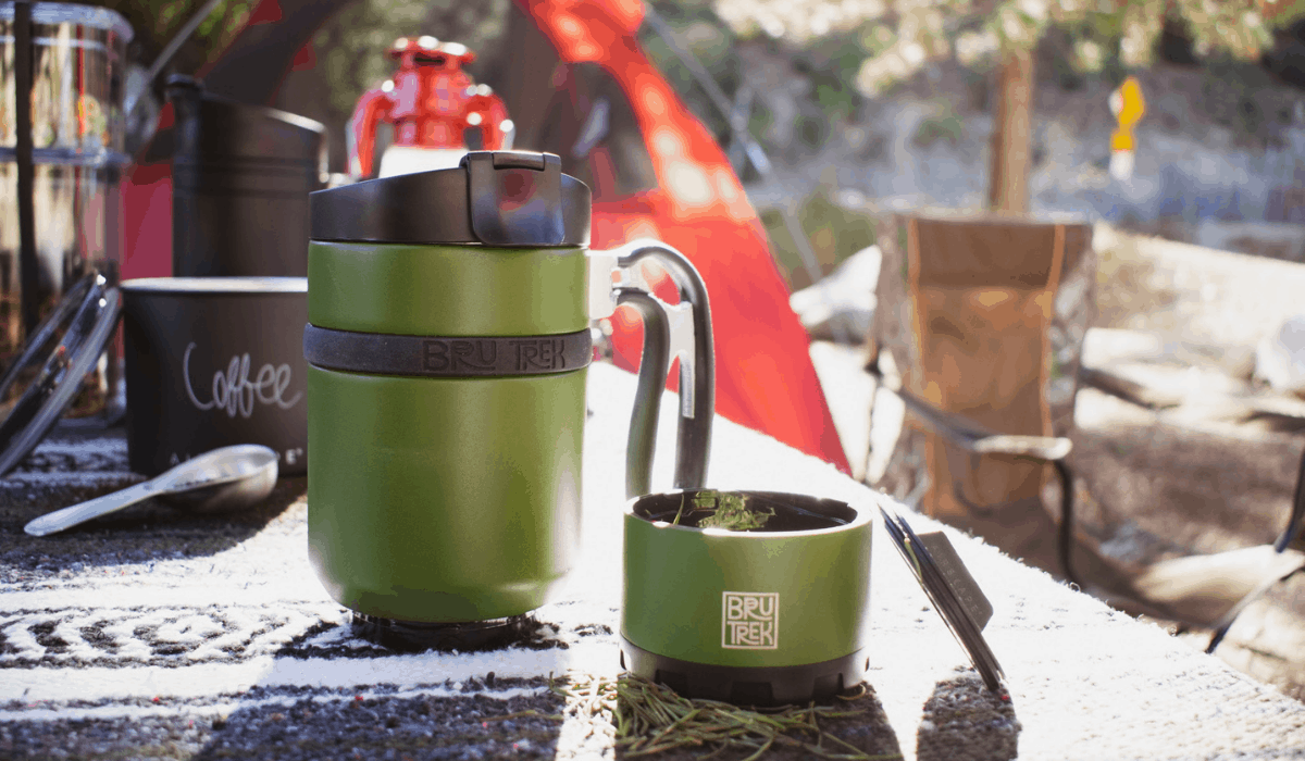 Double shot bru-trek French press on a picnic table with camping gear in the background