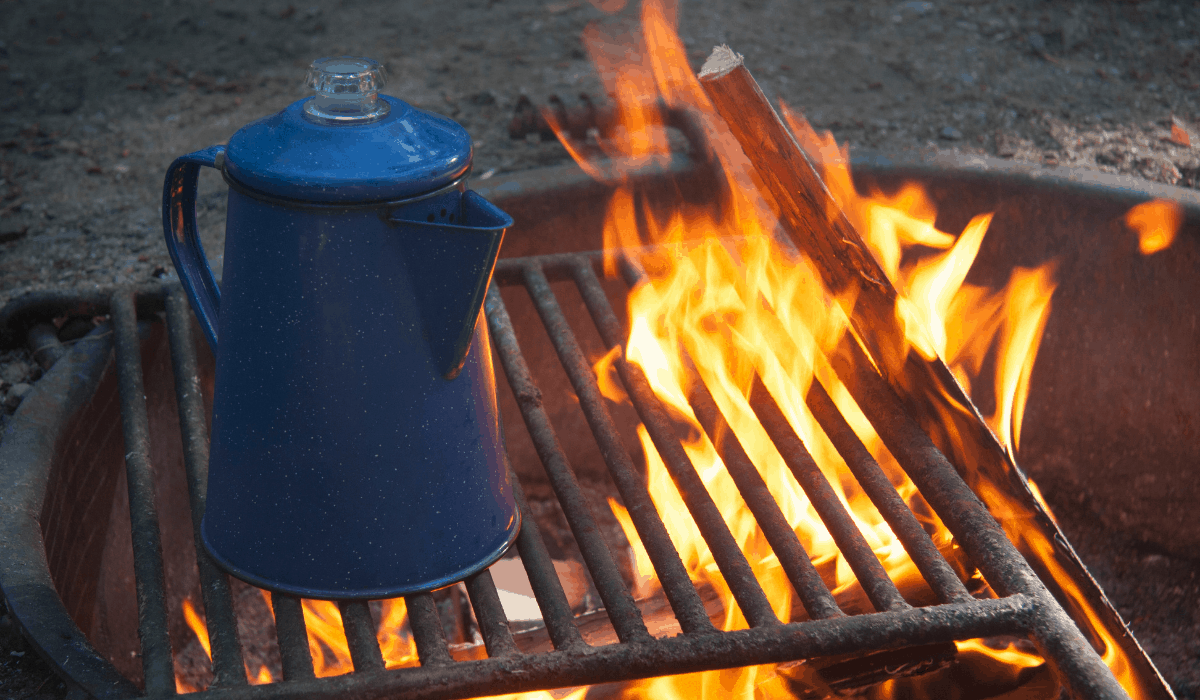 Blue Enamel Percolator Coffee Maker on the grate of a campfire