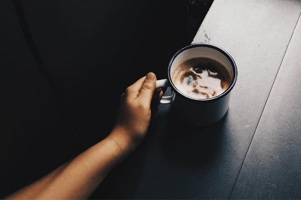 coffee brew bags office A hand holding a cup of iced coffee on a table