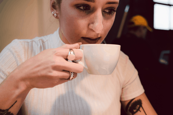 woman sipping a cup of coffee and looking down