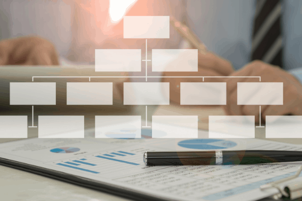 Blank organization chart in front of a blurred office table background